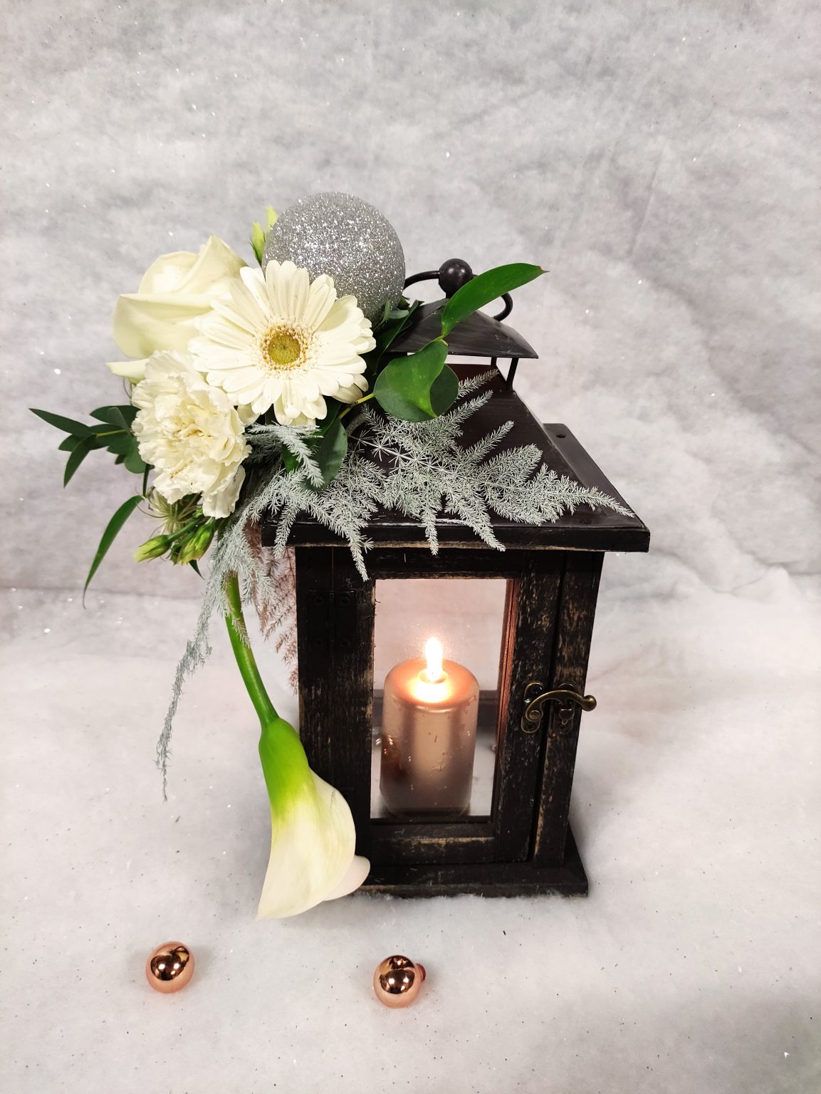 lanterne acompagnéé de fleurs et d'une bougie