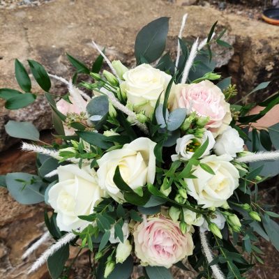 bouquet de mariée de roses blanche et roses pales accompagné de feuillage te de fleurs sechées